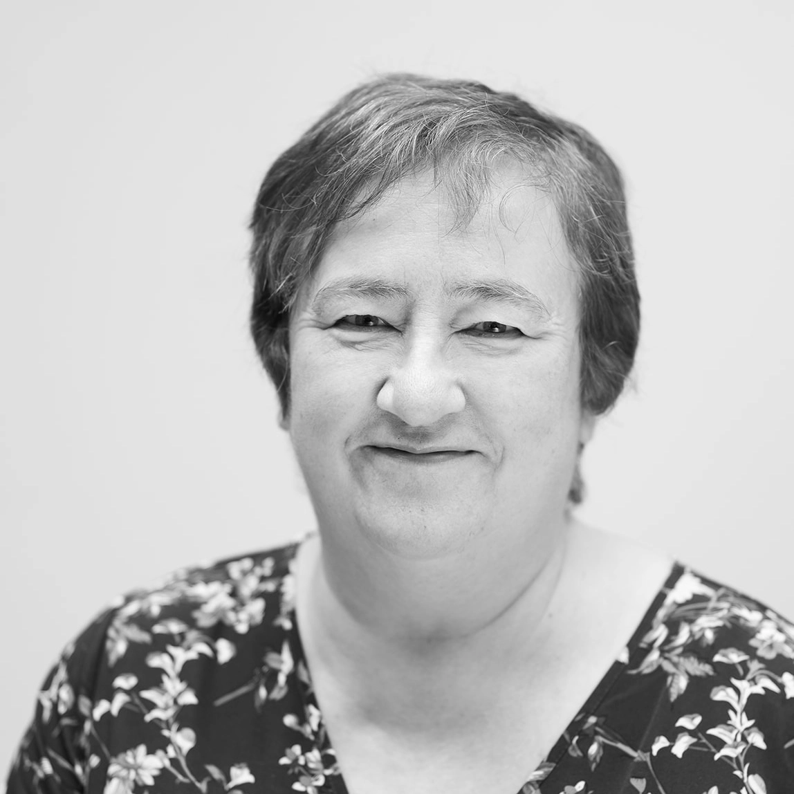 A black and white headshot of a smiling woman