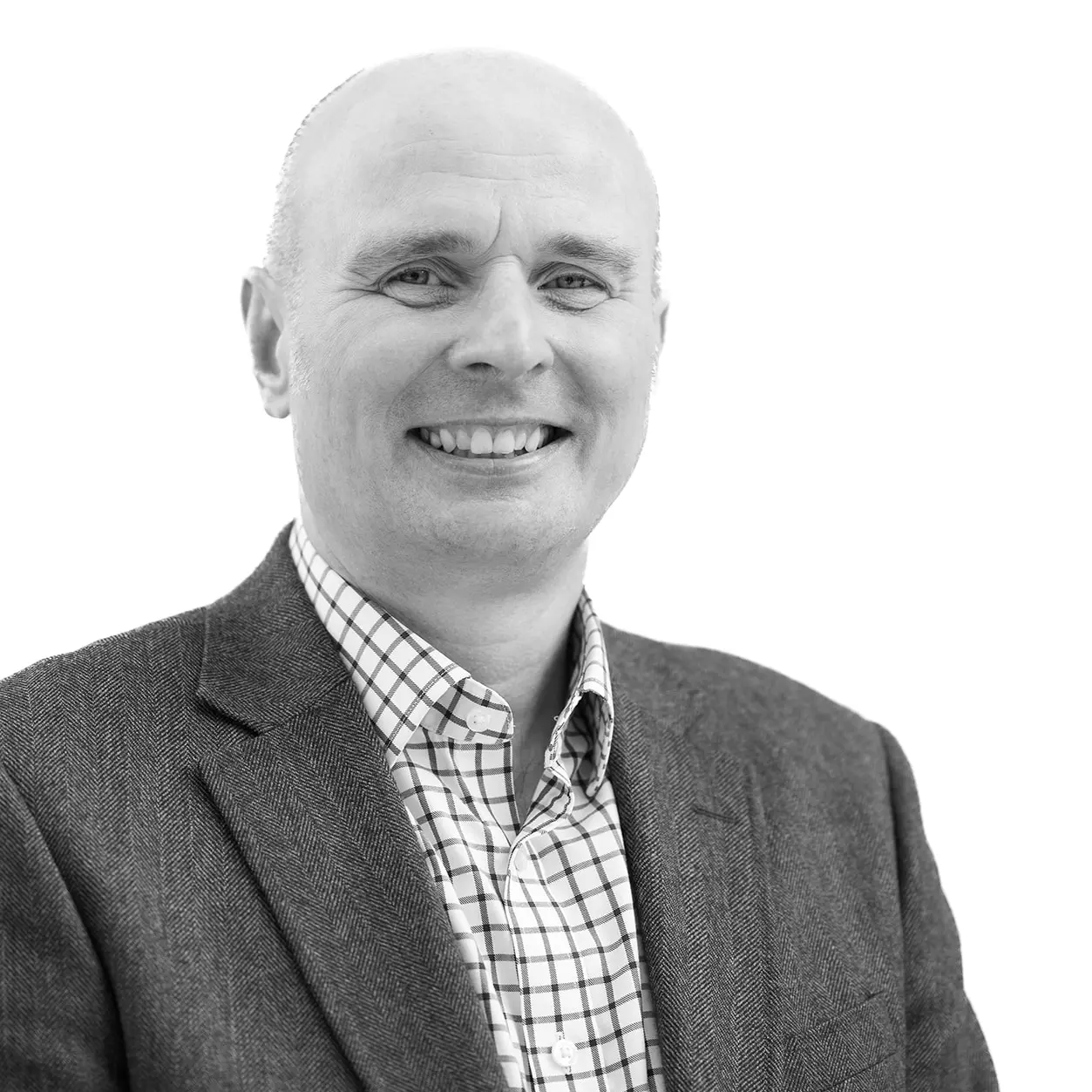 A black and white headshot image of a smiling man against a white backdrop
