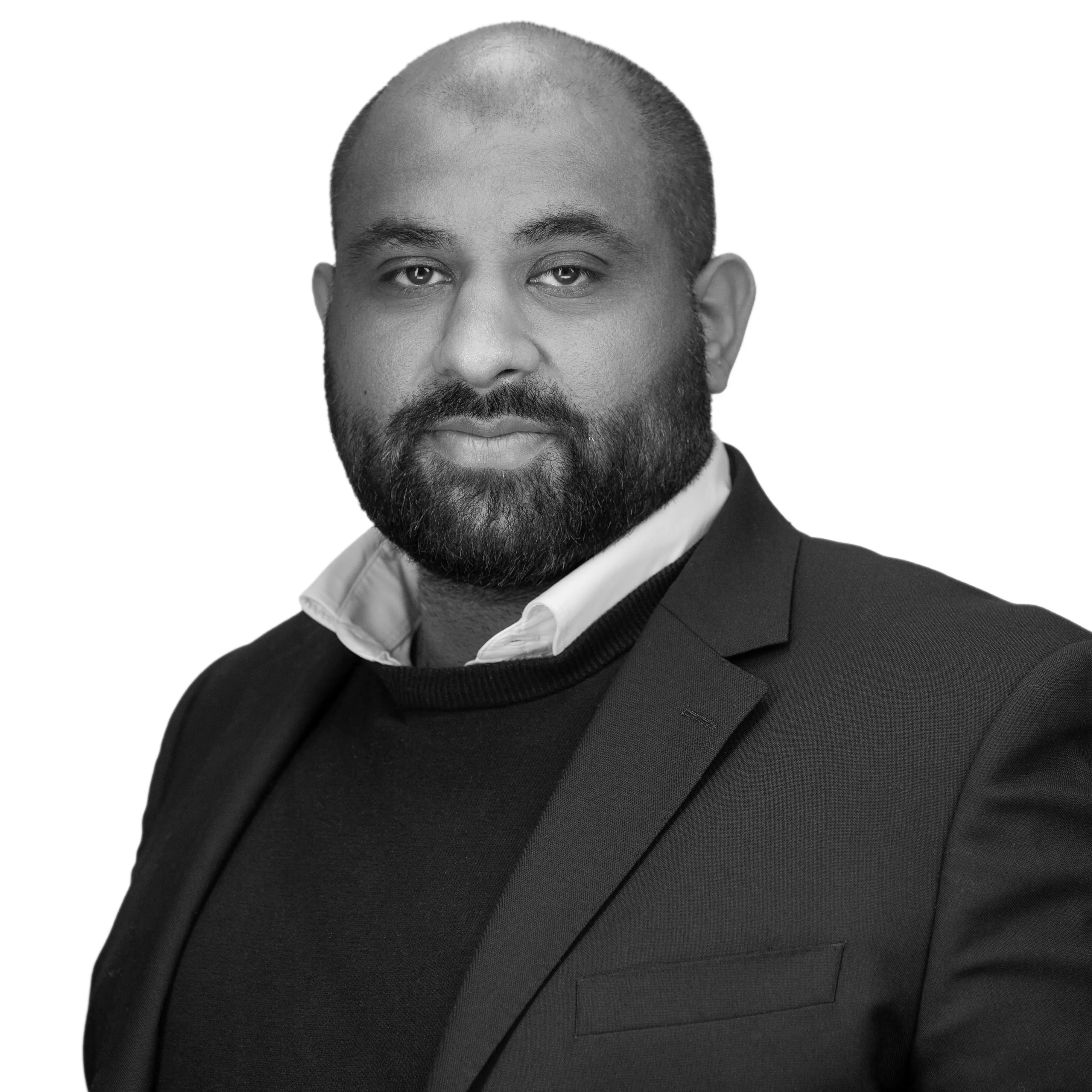 A black and white headshot image of a smiling man against a white backdrop