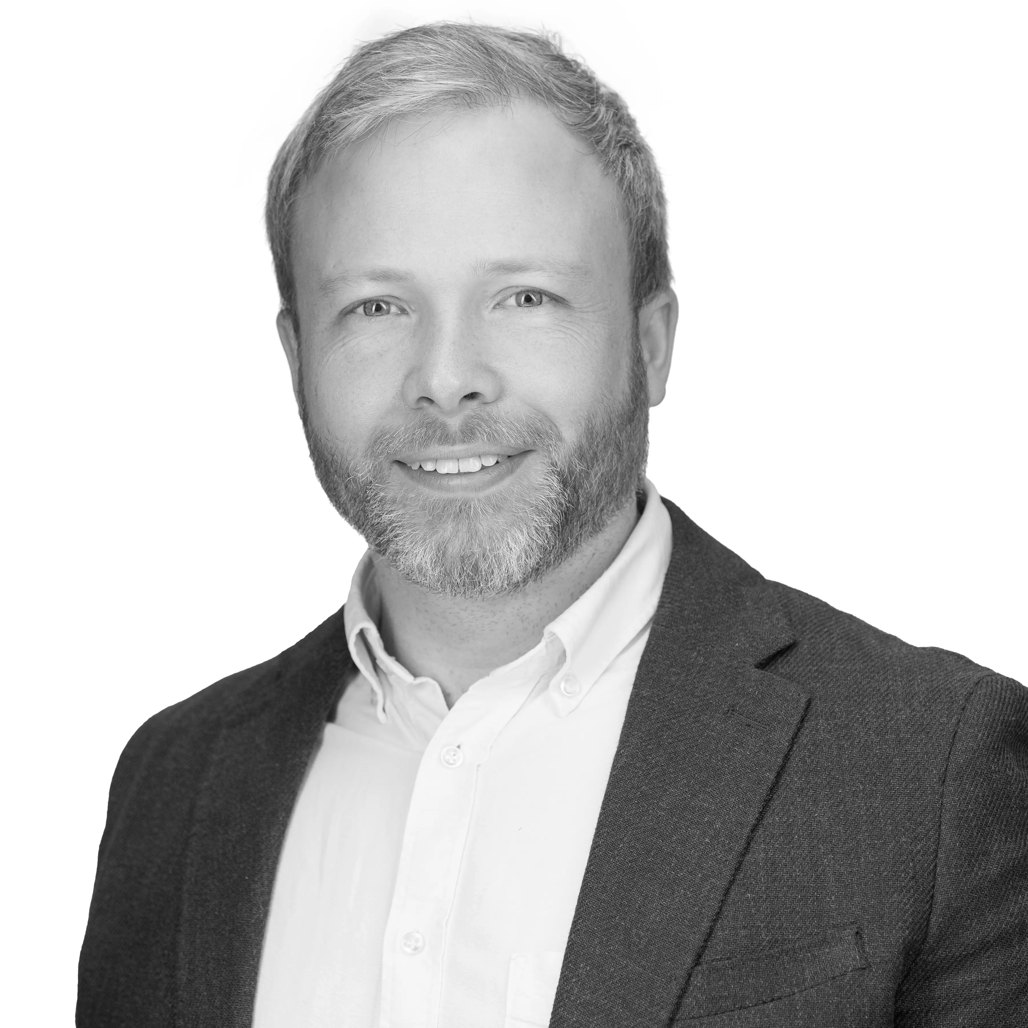 A black and white headshot image of a smiling man against a white backdrop