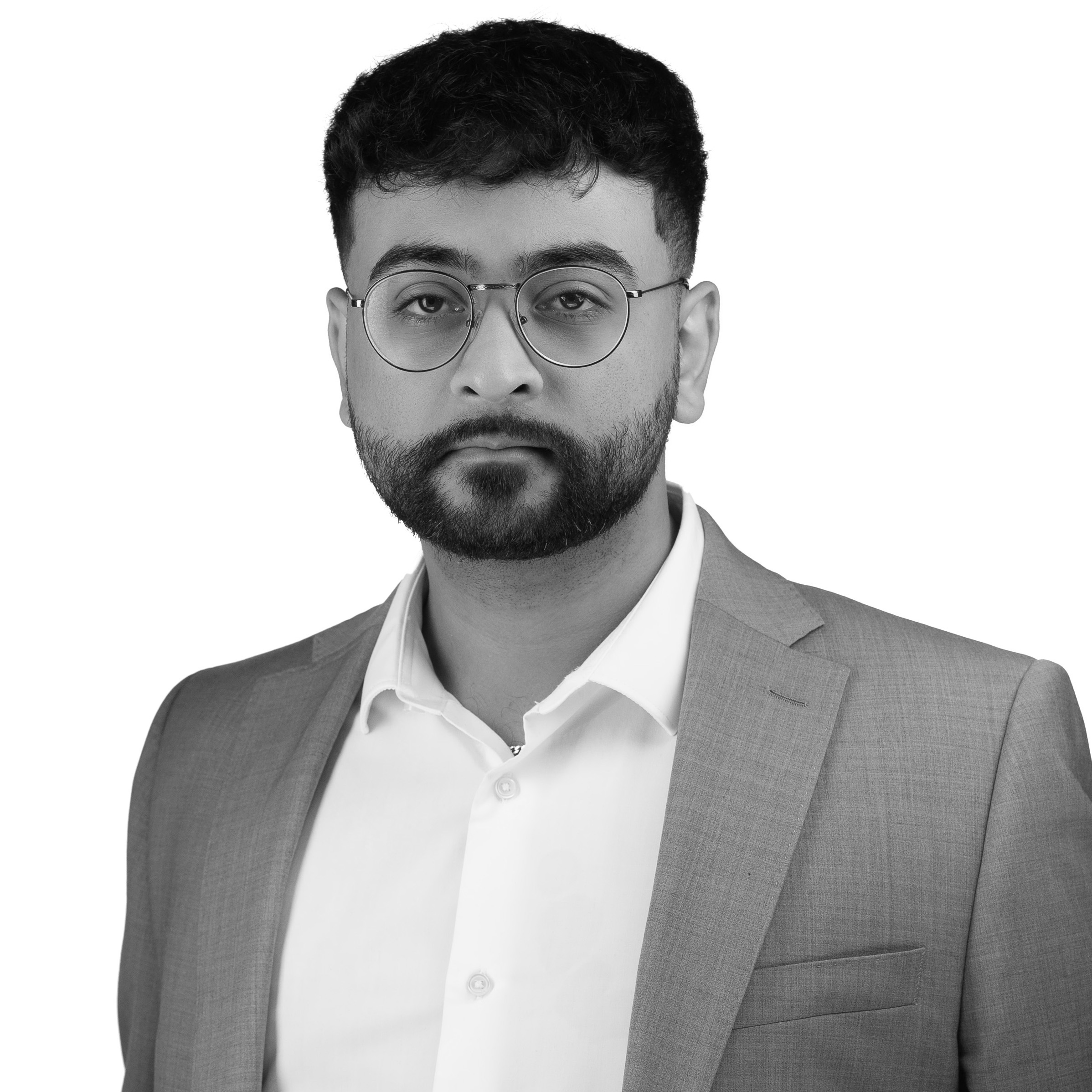 A black and white headshot image of a smiling man with glasses against a white backdrop