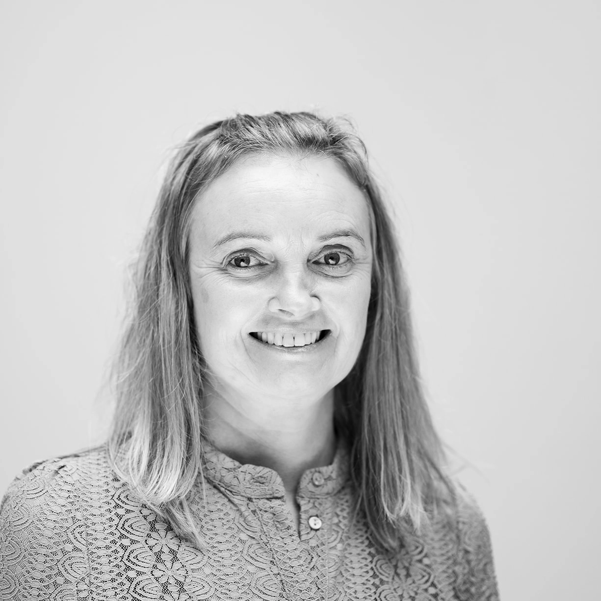 A black and white headshot of a smiling woman