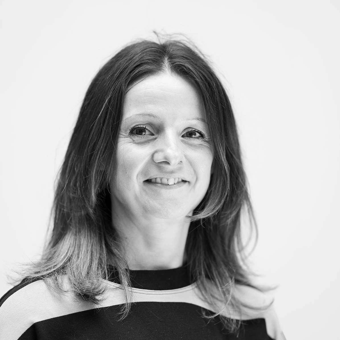 A black and white headshot image of a smiling woman