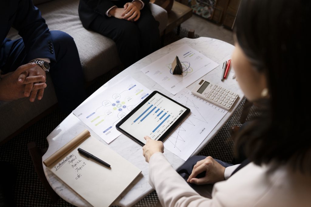 Four business people reviewing charts around a table.