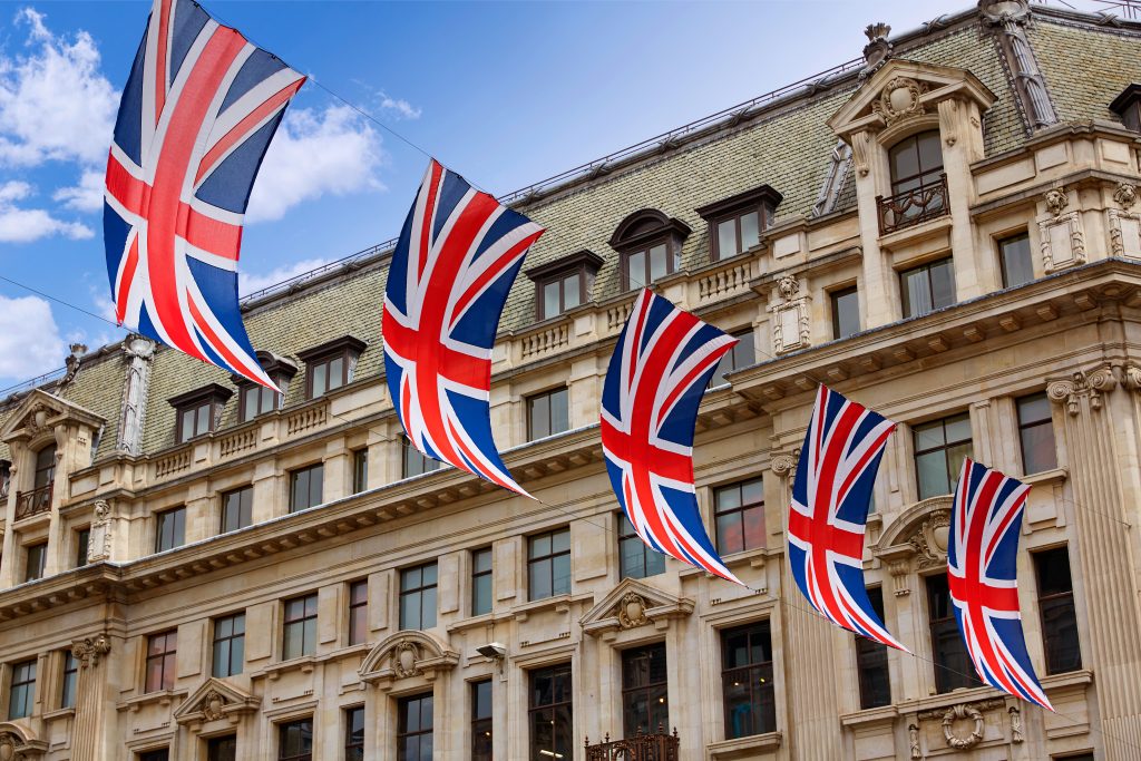 Union Jack flags lining the streets in celebration against typical Victorian architecture.