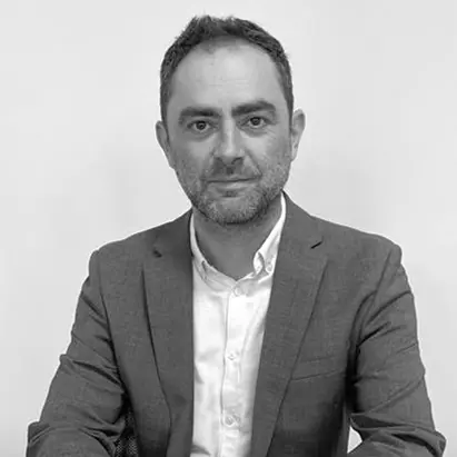 A black and white headshot of a smiling man