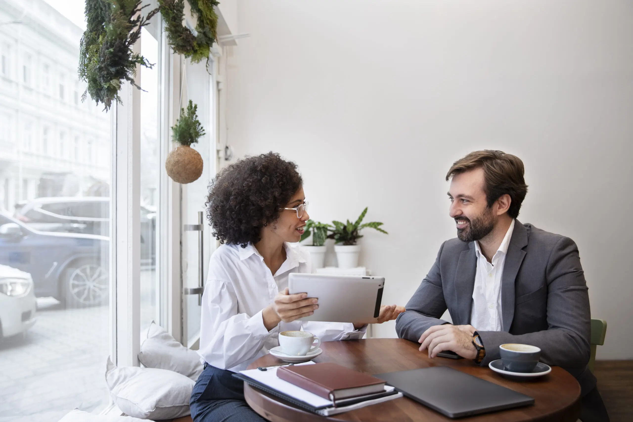 Two colleagues working together over coffee.