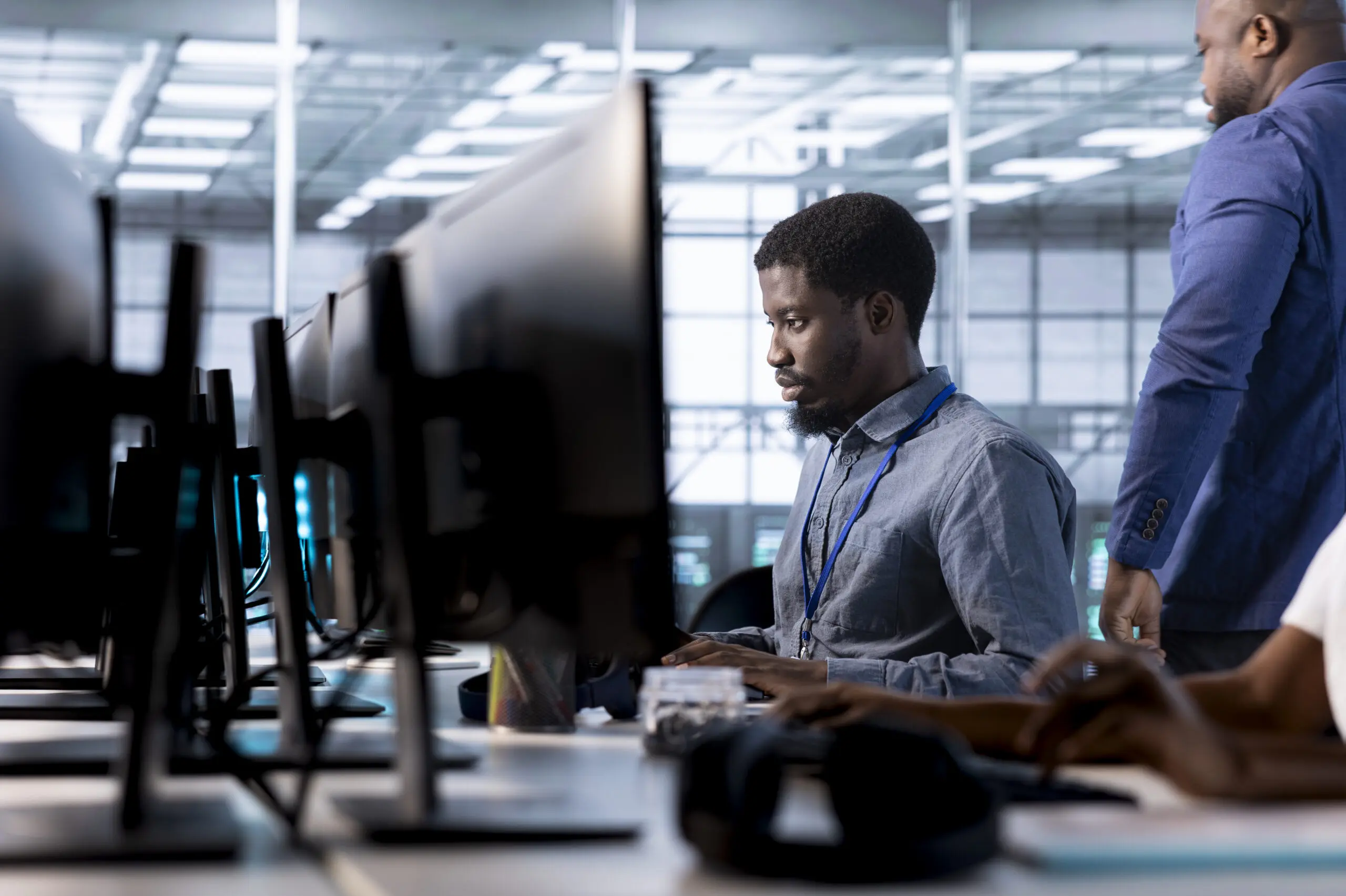 Engineer next to coworkers in server farm checking recovery plan, monitoring data center energy consumption. Employee and colleagues in server room doing routine disk checks