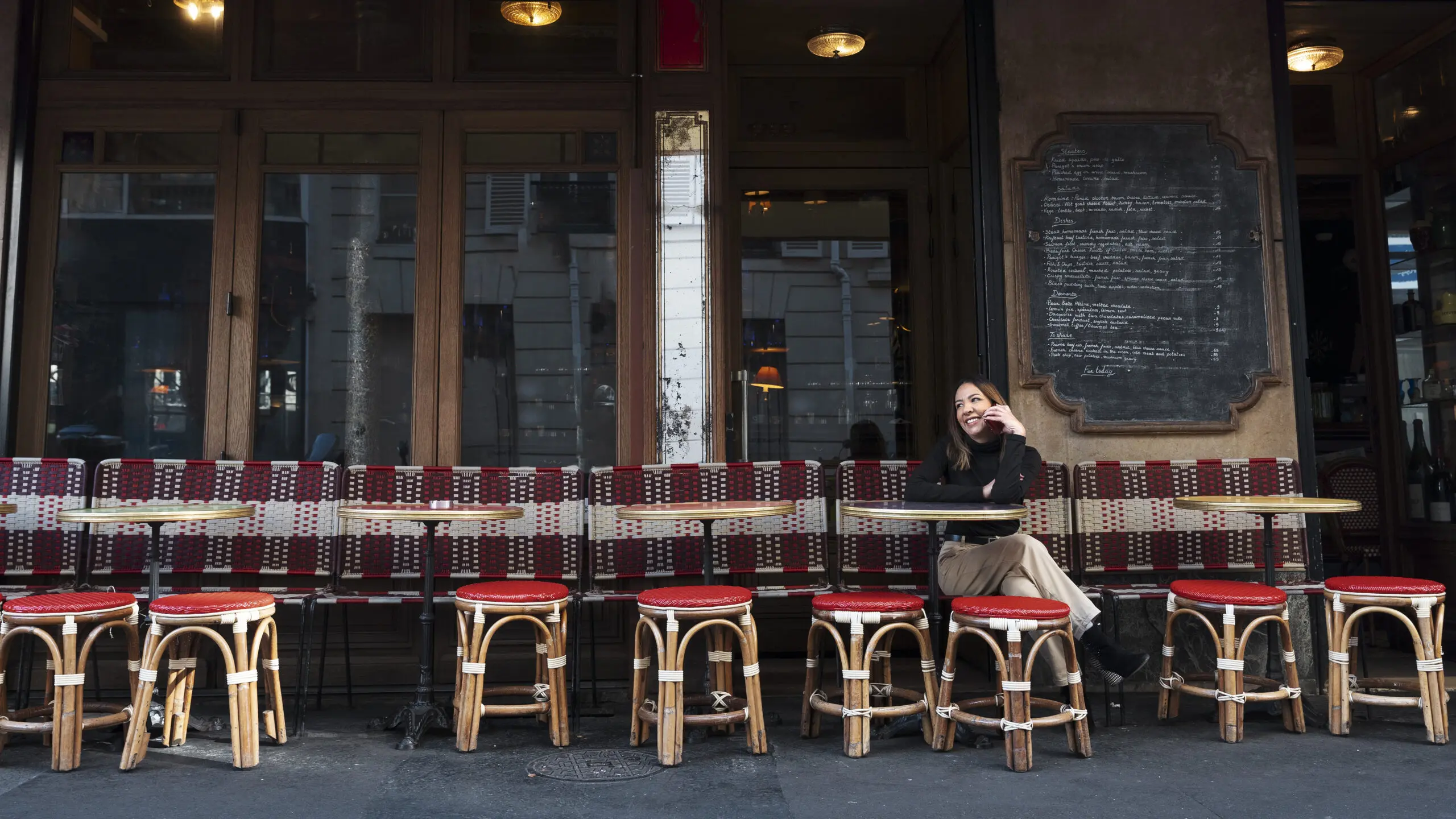 A smiley woman sitting at a bistro