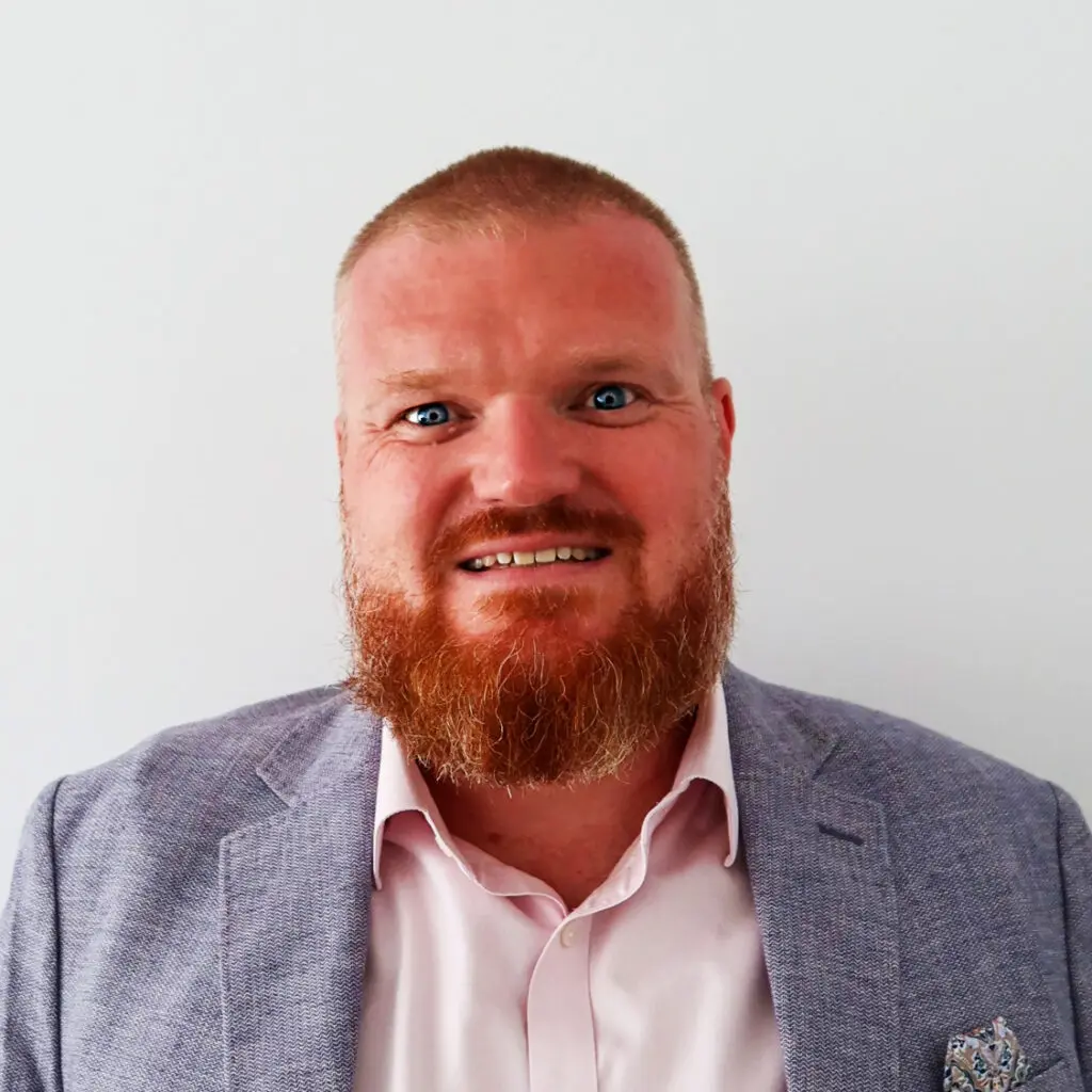 A colour headshot of a smiling man