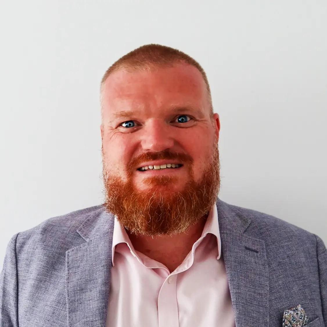 A colour headshot of a smiling man