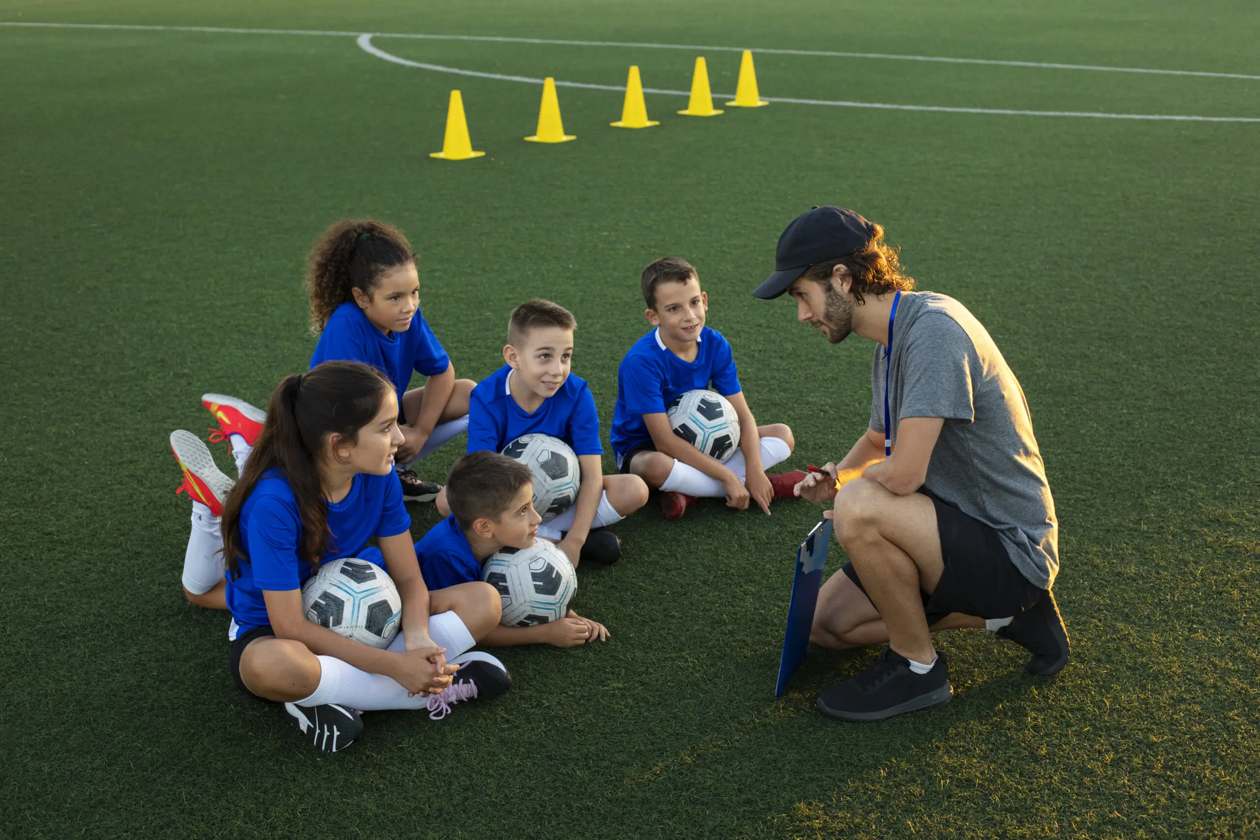 Football trainer teaching kids side view