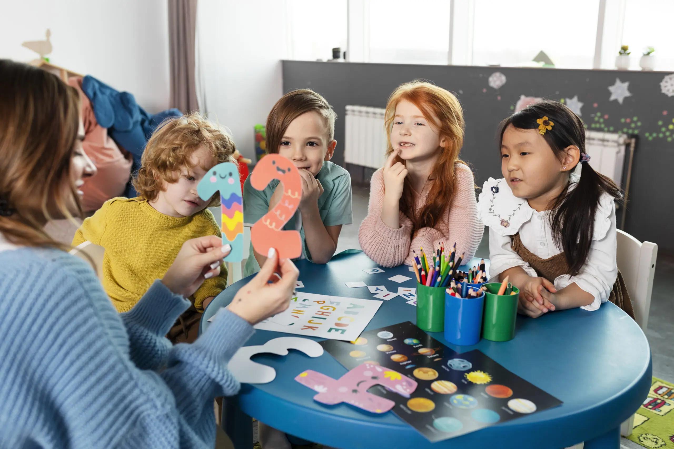 children sitting around a table learning numbers